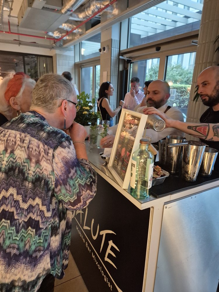 Salute bartender shaking a cocktail as a guest watches