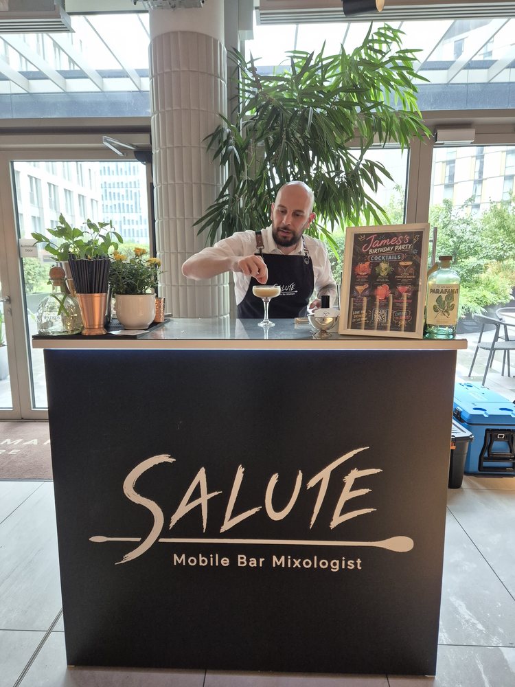 Two Salute bartenders serving a guest at the mobile bar